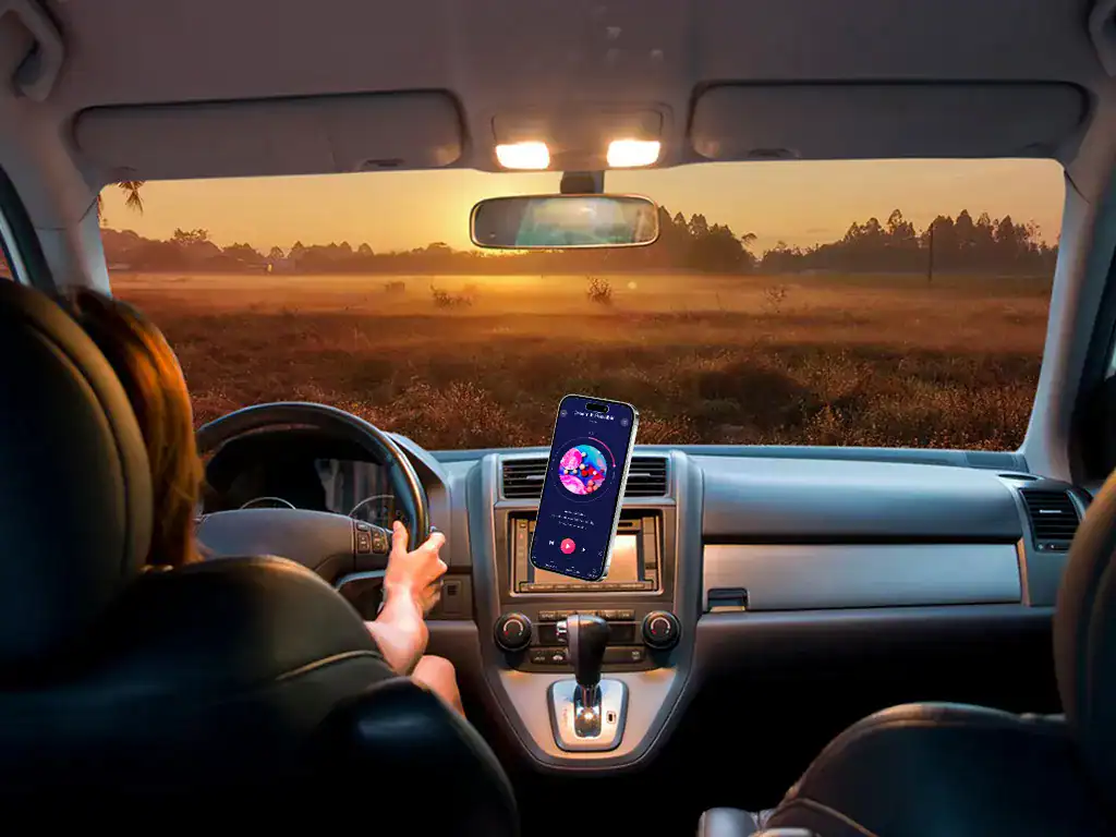 Viagem de carro ao nascer do sol com smartphone preso ao painel, transmitindo músicas ou chamadas em um ambiente confortável e moderno.