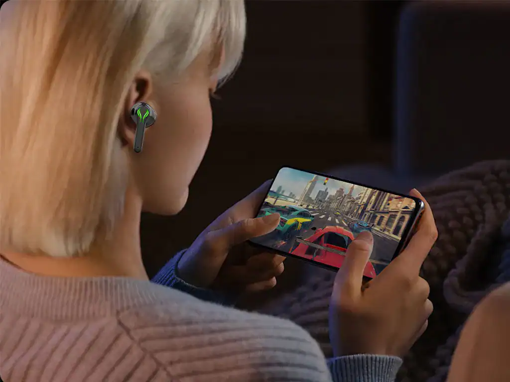 Aparelho de áudio sem fio em ouvido de mulher jogando jogo de corrida em smartphone com cidade urbana ao fundo.